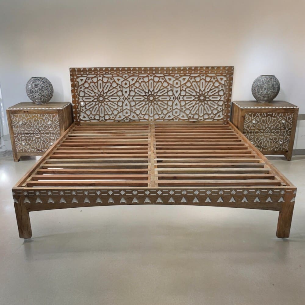 hand-crafted solid wood king bedframe staged in a light room with matching nightstands and round lamps