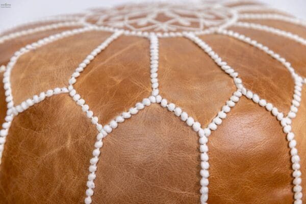 A close up of the leather surface of a pouf