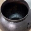 A metal pot sitting on top of the floor.