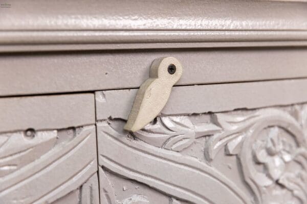 A close up of the door handle on an old dresser