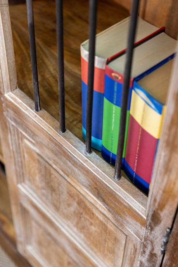 A wooden cabinet with some books and boxes