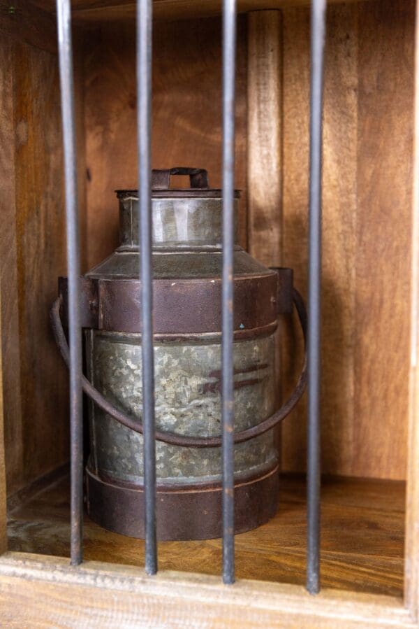 A metal container sitting in the middle of a wooden box.