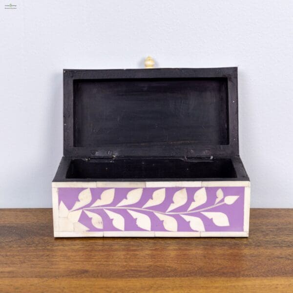 A wooden box with a purple and white design on the front.