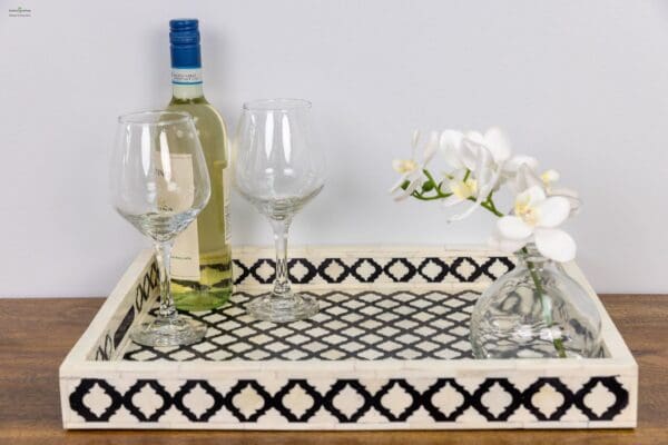 A bottle of wine and two glasses on top of a tray.