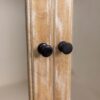A close up of two knobs on the side of a door.