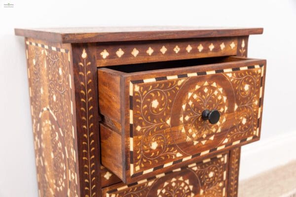 A close up of the drawer on an ornate chest