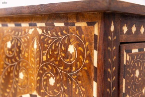 A close up of the front of an ornate wooden cabinet.