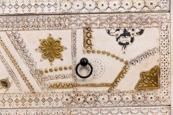 A close up of the ceiling with gold and white designs