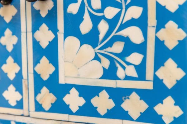 A blue and white tile wall with a floral design.