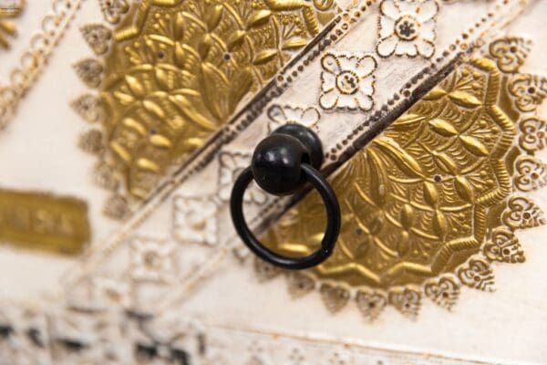 A black ring hanging on the side of a gold wall.