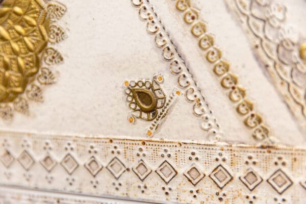 A close up of the gold trim on a white purse.