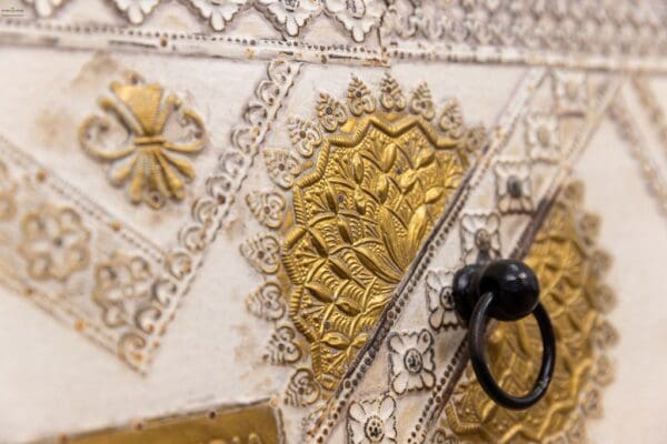 A close up of the gold and silver designs on a purse.