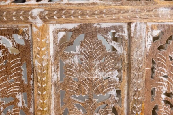 A close up of the carved wood frame on an old wooden chair.