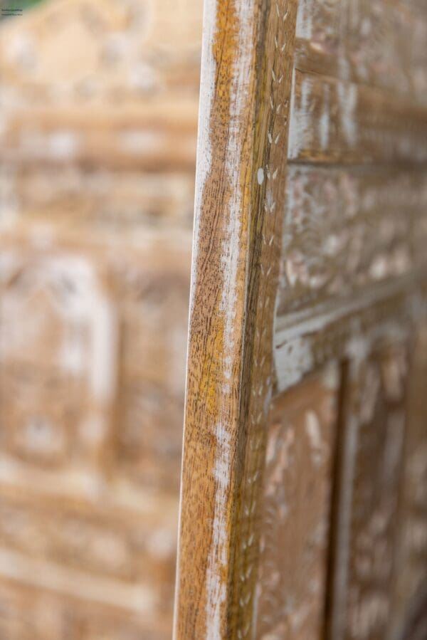 A close up of the corner of an old wooden door.