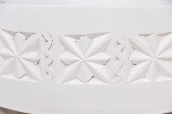 A close up of the white pattern on the side of a bowl