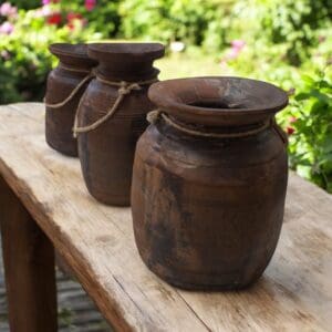 Hand-crafted vintage acacia wood vases. Staged on a rustic bench in a garden. Each one is unique with a story to tell, many sizes available.