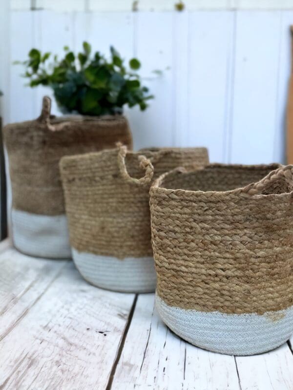 A group of four baskets sitting on top of a wooden table.