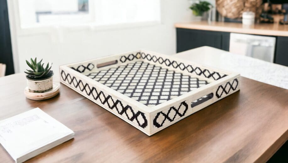 A wooden tray with black and white design on top of a table.