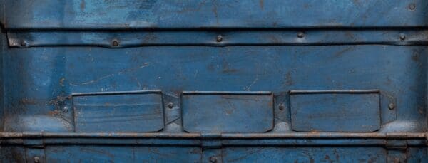 A close up of the front of an old blue truck.