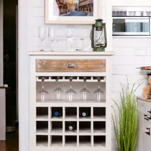 A white wine rack with many glasses on top of it.