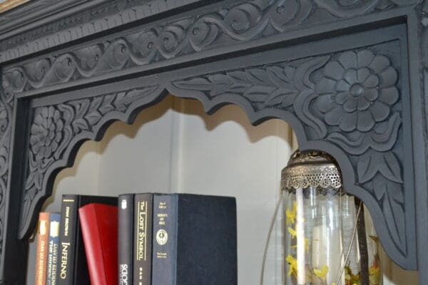 A close up of books and a jar on the shelf