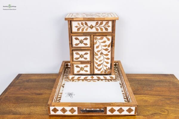 A wooden table with two trays and one box.