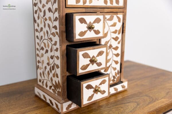 A wooden jewelry box with brown and white designs.