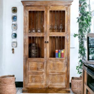 A wooden farmhouse china cabinet with glass doors and shelves.