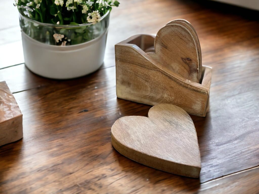 A set of four heart shaped coasters with a holder staged on a countertop. Coaster Set