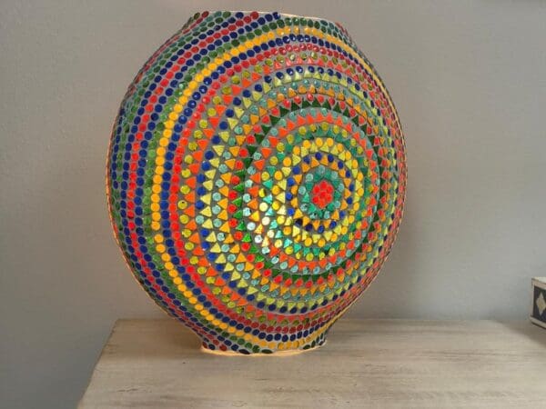 A colorful bowl sitting on top of a wooden table.