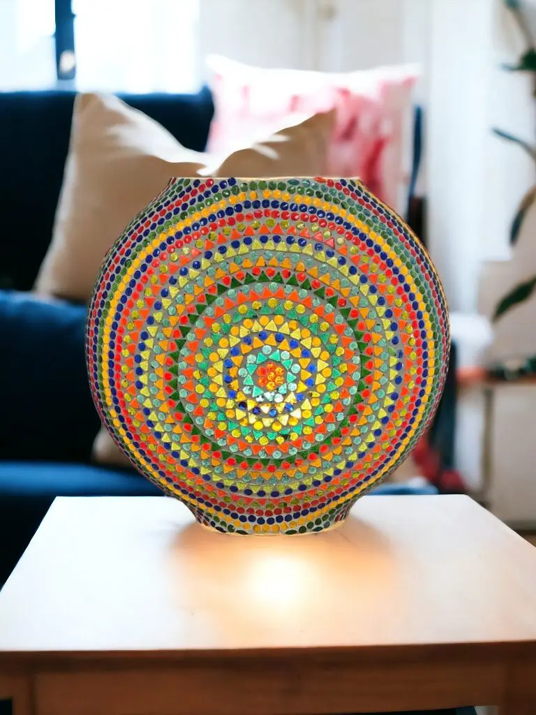 Multicolor round mosaic glass lamp sitting on top of a table.