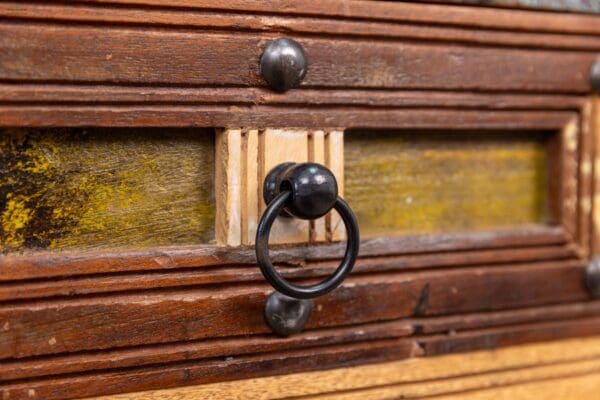 A close up of the handle on an old wooden chest.