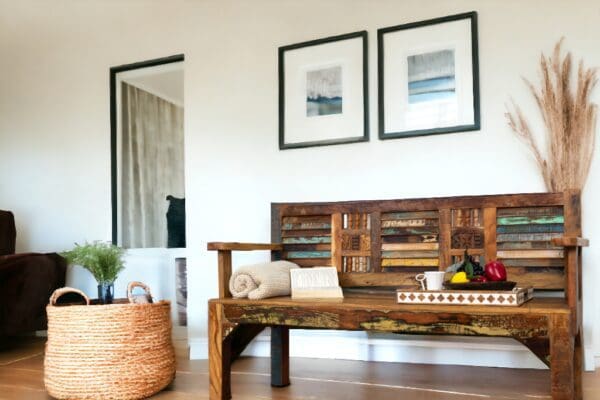 A wooden bench in front of two framed pictures.