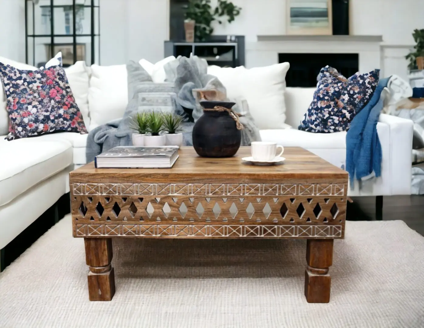 Hand-crafted natural wood square coffee table with hand-carved detail staged in a living room with decorative accents.