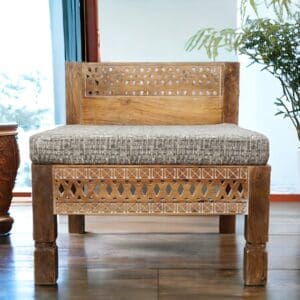 Oversized square chair, hand-crafted solid mango wood with cut out details. Staged in a living room.