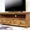 hand-crafted solid natural wood TV stand with 3 carved drawers staged with a TV in a living room