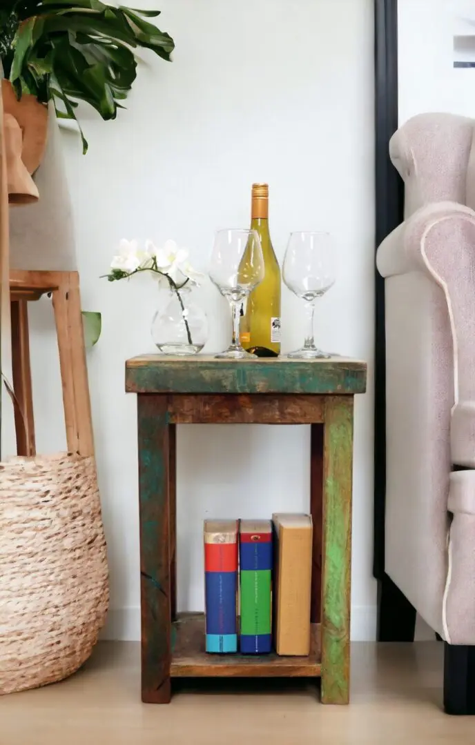 A reclaimed wood side table with decorative accents staged in a living room. Multicolored wood square tall table with a bottom shelf.