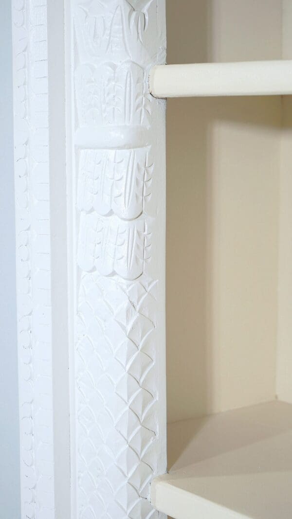 A white pillar with designs on it.