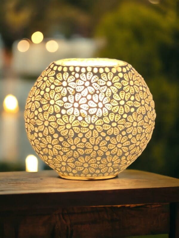 A white lamp with flowers on it sitting on top of a table.