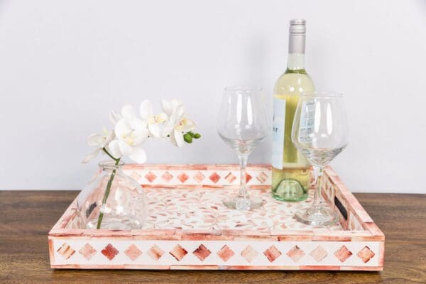 A bottle of wine and two glasses on a tray.