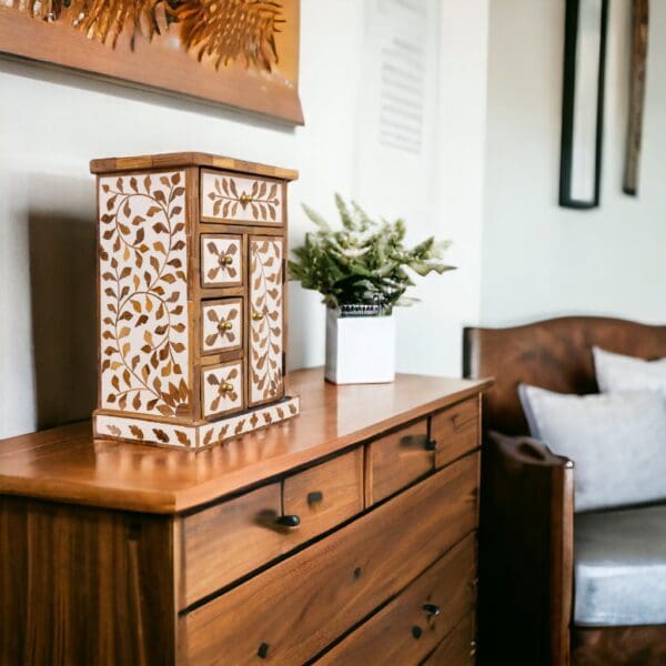 A wooden dresser with a vase on top of it.