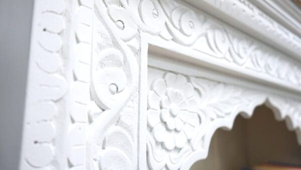 A close up of the ornate white carved wood.