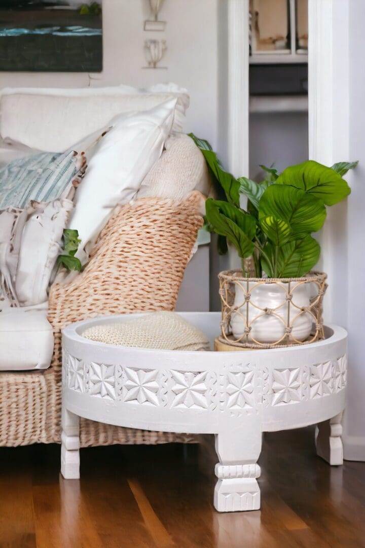 A white table with a plant on top of it.