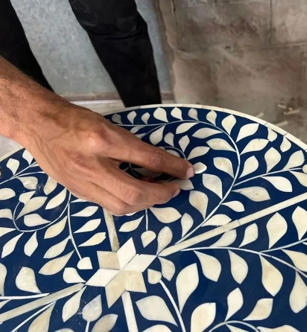 A person is painting the design on a table.