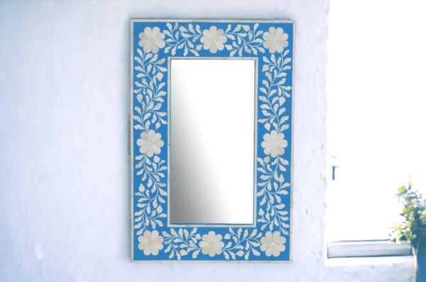 A mirror with blue and white floral design.