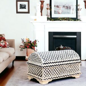 A black and white bone inlay trunk in a living room with a fireplace and a couch