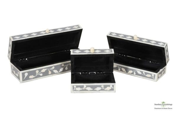 Three black and white boxes with a lid open.