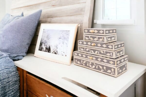 A set of 3 inlay boxes next to a picture frame sitting on top of a desk.