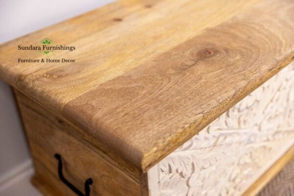 A wooden box with a carved lid on top of it.