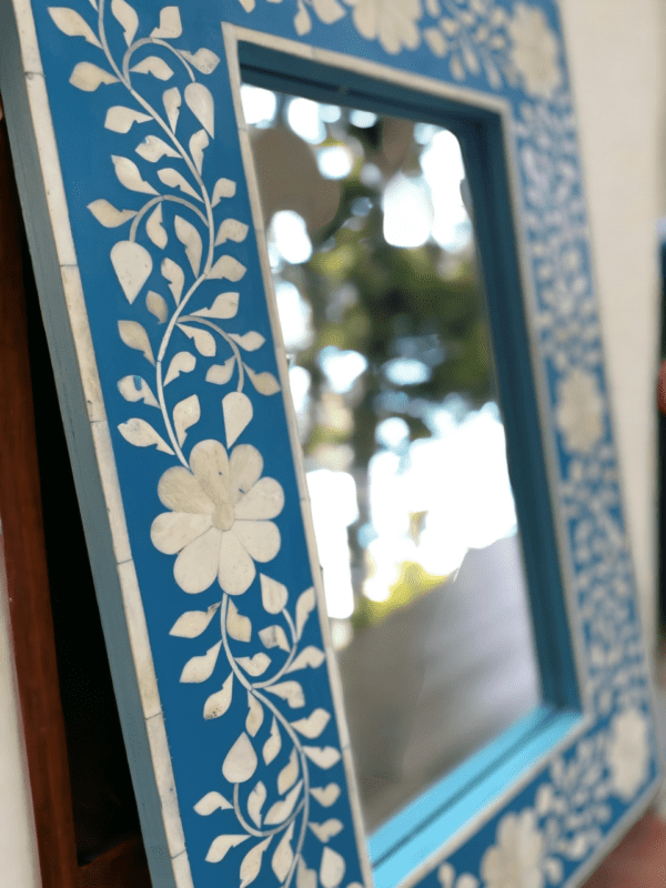 A mirror with blue and white floral design.